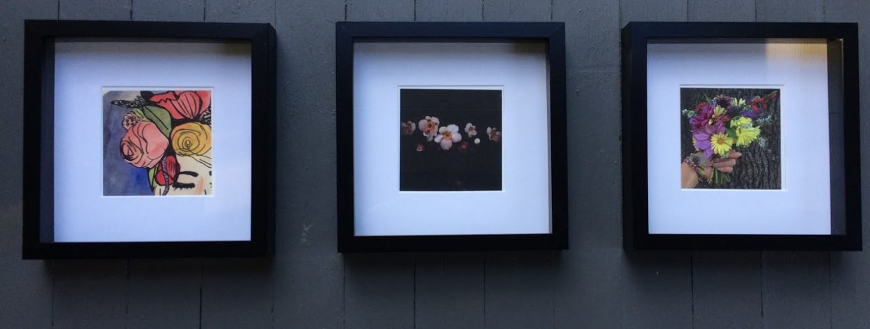 Three works of art in square, black frames with white mattes. The first is a drawing and watercolor of a flower arrangement, the second is a photograph of flowers with a dark, mysterious feeling, and the last image is a floral arrangement.