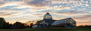 The Conservatory with sunset colors and clouds behind