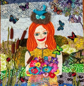 Image of a textile art piece showcasing a redheaded girl in nature